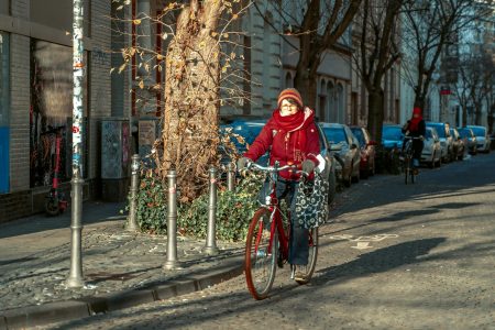 Vrouw op fiets met sjaal en winterjas