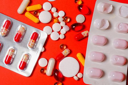 Verzameling medicijnen op rode ondergrond