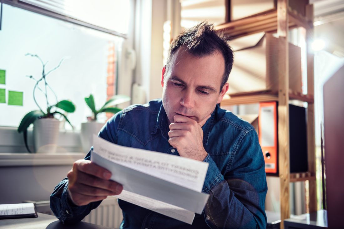 Man  aan bureau bekijkt document