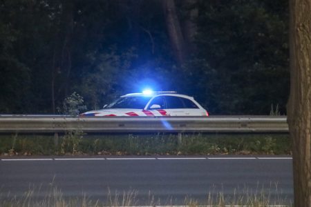 Politieauto met zwaailicht op snelweg