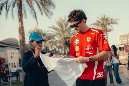 Charles Leclerc deelt een handtekening uit aan een jeugdige fan